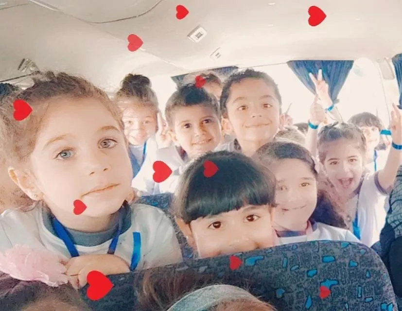 Children holding paper hearts they made